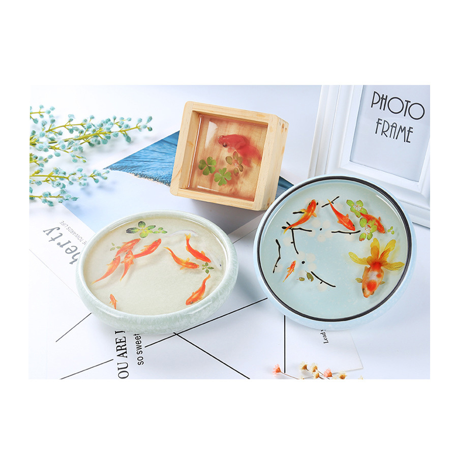 Self-adhesive sticker for embedding in epoxy resin to achieve a hand-painted layered effect, featuring a golden fish, with an image size of 56x32 mm