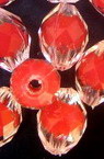 Мънисто с червена основа овал 13.5x10 мм дупка 2 мм многостенно прозрачно -50 грама ~ 70 броя